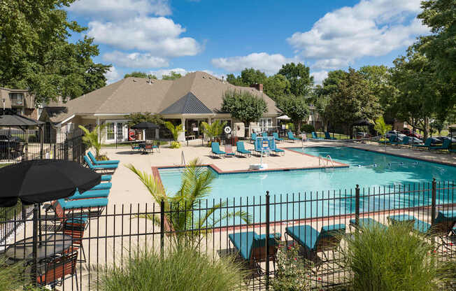 A pool area with a gazebo and lounge chairs.
