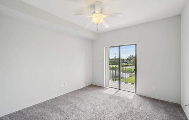 A room with a ceiling fan and carpeted floor.