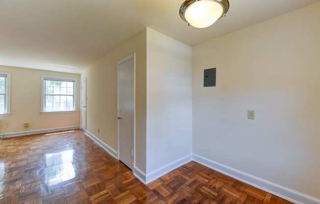 vacant dining area with view of living area with hardwood floors and large windows atcolonnade apartments in washington dc