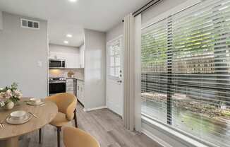 a breakfast nook with a large window and a table and chairs