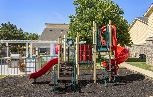 Playground area with colorful slides and climbing equipment outside of Edmond apartment community