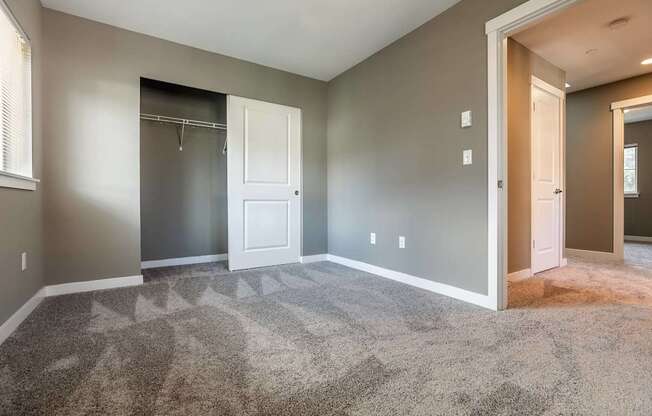 A room with a carpeted floor and a white door.