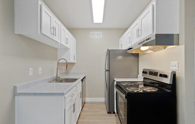 a kitchen with white cabinets and a black stove and refrigerator