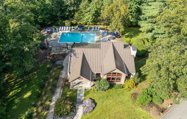 an aerial view of a house with a swimming pool and a yard with chairs