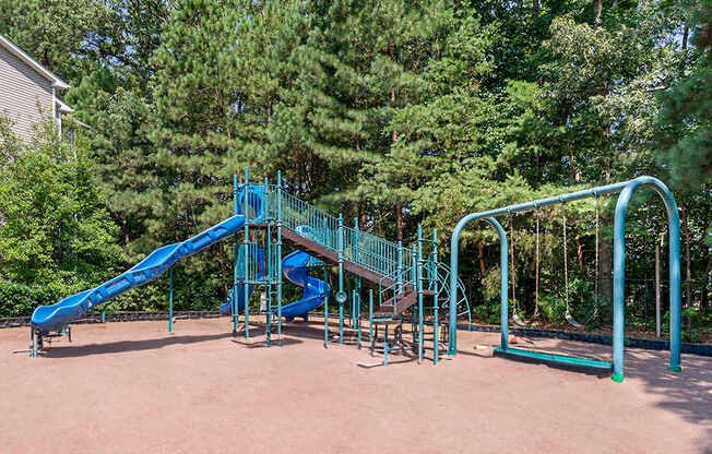a playground with a blue slide and a staircase