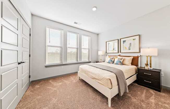 A bedroom with a bed, dresser, and two framed pictures on the wall