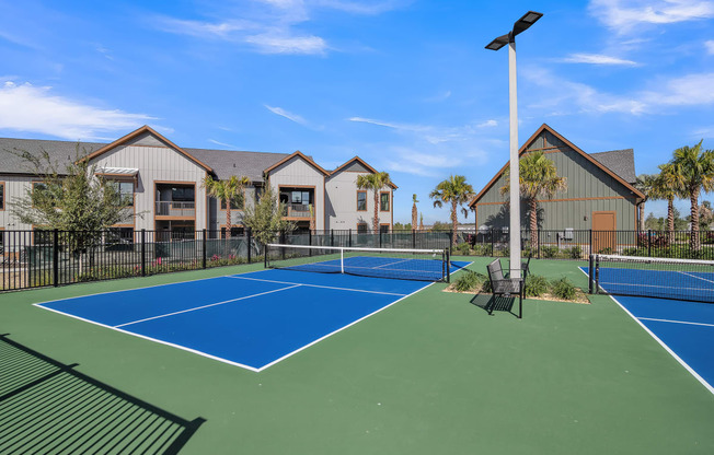 two tennis courts with apartments in the background at Canter, Ocala, FL