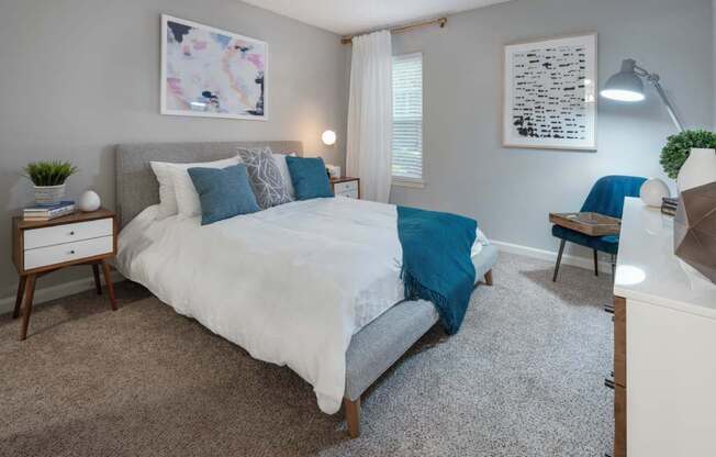 Veridian at Sandy Springs apartments interior bedroom with a bed and a desk with a chair
