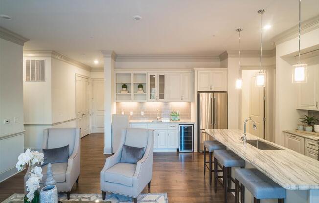 Combined kitchen and living area with elegant furnishings, featuring a built-in wine cooler and stylish decor.