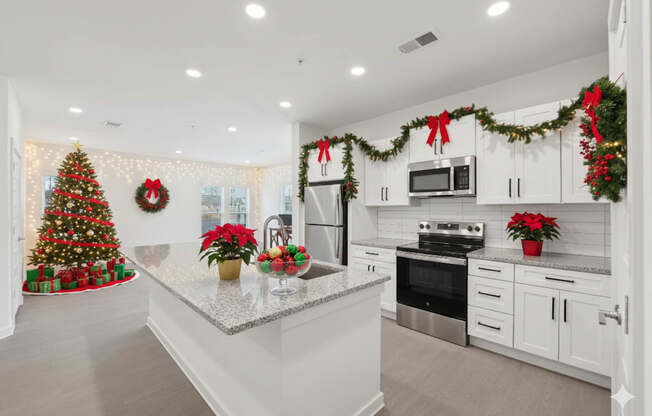A kitchen decorated for Christmas with a tree, wreaths, and garlands.