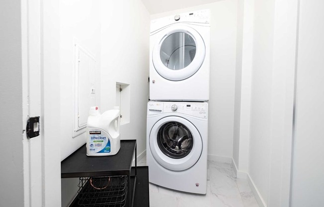 A white washing machine is in a small laundry room.