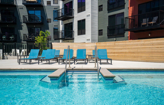 Pool and pool seating with apartment units' balconies in the background