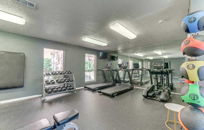A gym with a variety of equipment including treadmills, weights, and exercise machines at Copper Hill Apartments, Bedford 76021