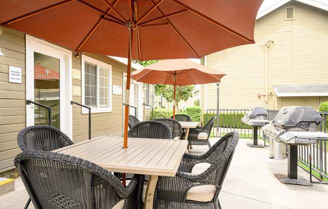 a patio with a table and chairs and an umbrella at Sagewood Gardens Senior Apartments, Hacienda Heights, CA 91745