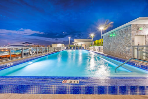 a swimming pool on the roof of a hotel at night