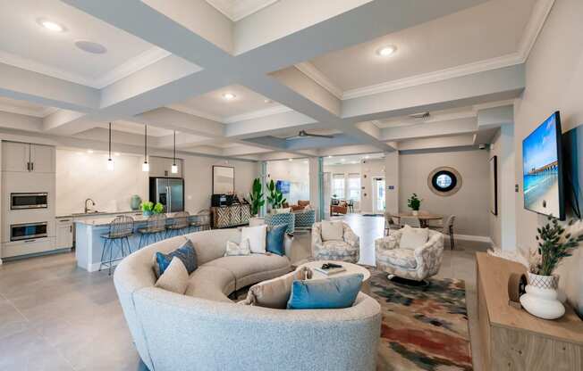 lounge area with a large couch, chairs, and a kitchen in the background at Vantage Luxury Apartments in Cape Coral, FL