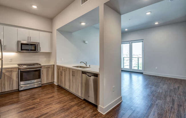 A kitchen with wood floors and a large window.