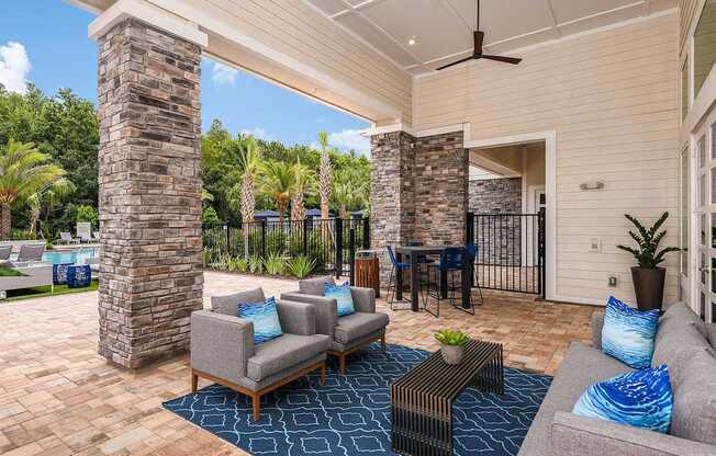 A patio with a table and chairs and a ceiling fan.