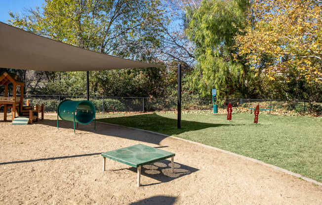 A playground with a green slide and a green table.