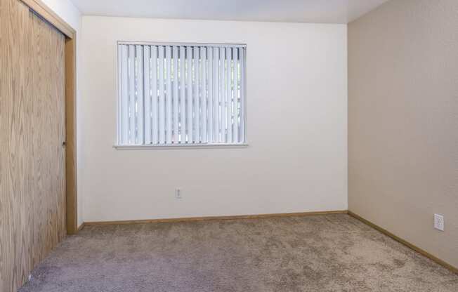 an empty room with a window and a carpet