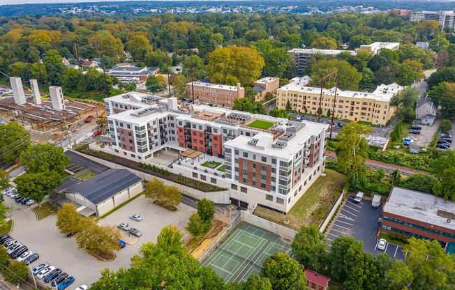 A large building with a tennis court in front of it.