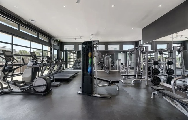 the gym has plenty of equipment and windows to the outdoors