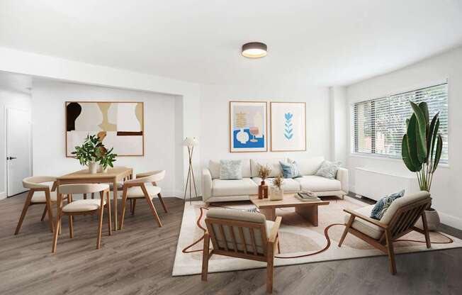 A living room with a white couch, wooden chairs, and a rug.