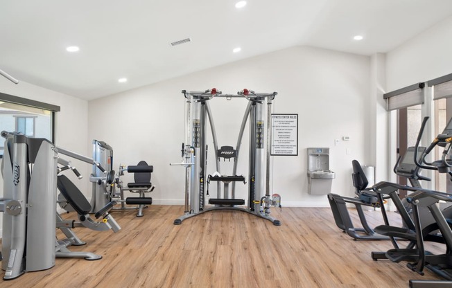 a fitness room with treadmills and other exercise equipment