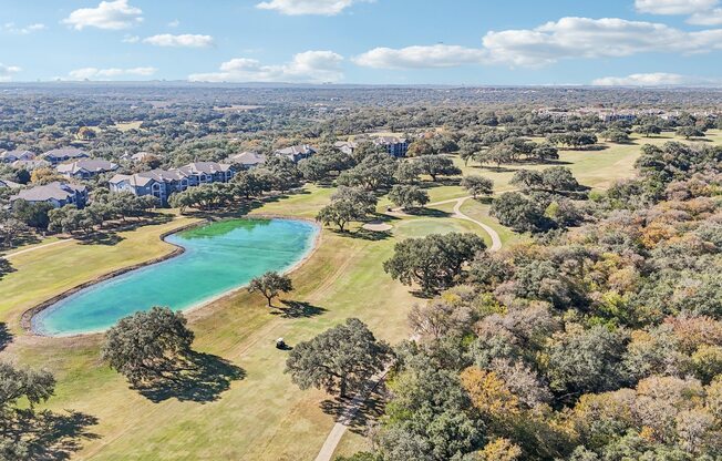 A beautiful aerial view of a park with a lake and trees.