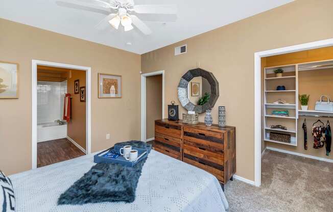 a bedroom with a bed and a dresser and a ceiling fan