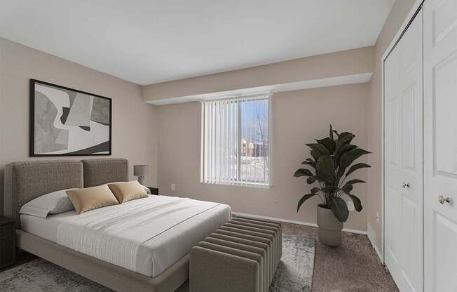 A bedroom with a large bed and a potted plant.