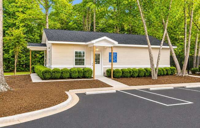 A small building with a parking lot in front of it.