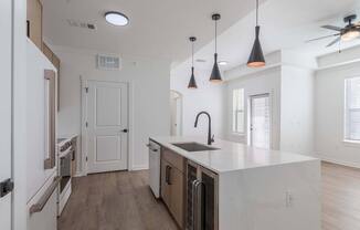 A kitchen with a white counter top and a ceiling fan.