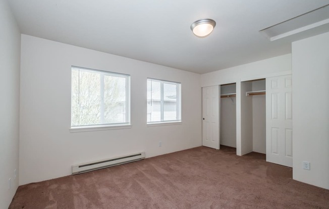 a bedroom with a carpeted floor and three windows