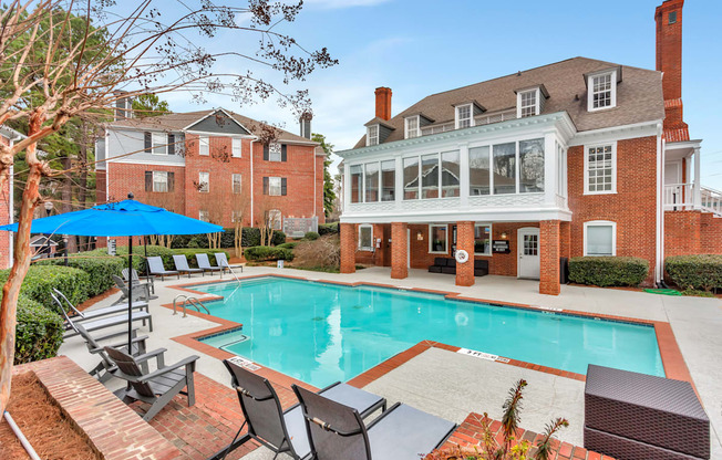 a swimming pool with chairs and a house in the background at Madison Brookhaven, Georgia