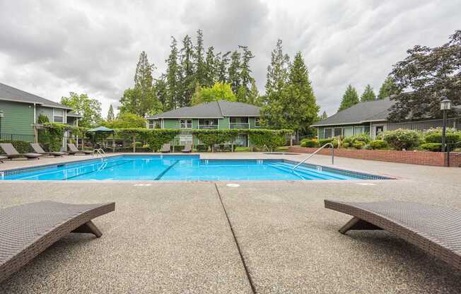 A pool surrounded by benches and trees.