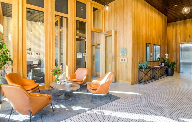 a lobby with orange chairs and a coffee table