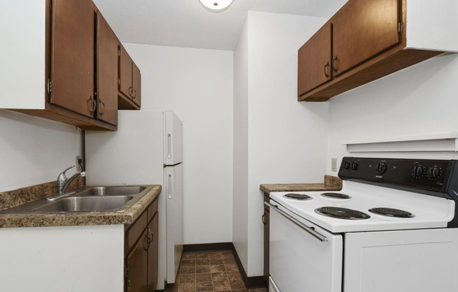 West St. Paul, MN Covington Courts Apartments. a kitchen with white appliances and brown cabinets