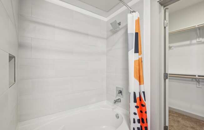 A white bathroom with a white tub and a white shower.