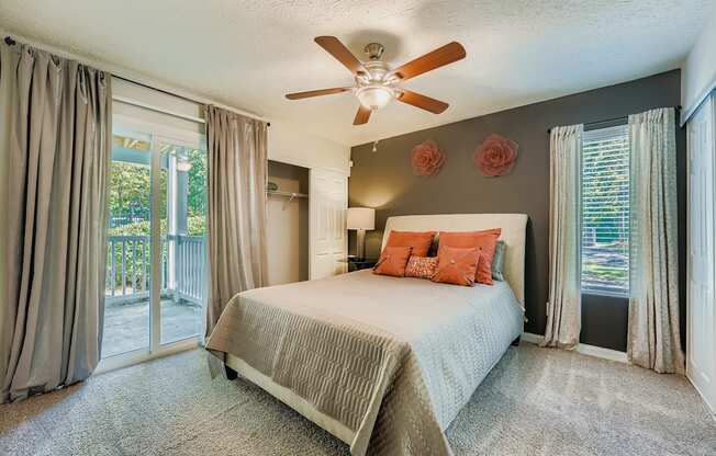 Bedroom with a bed, a ceiling fan, and a sliding glass door.