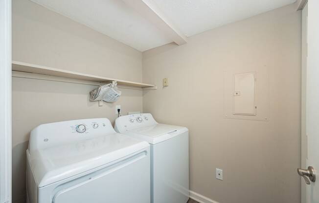 a white washer and dryer in a laundry room with a white door