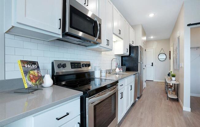 A kitchen with white cabinets and a black stove top oven.