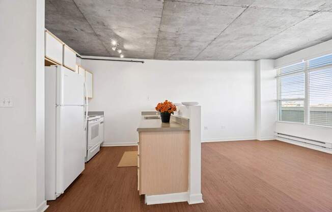 A kitchen with white appliances and wooden floors.