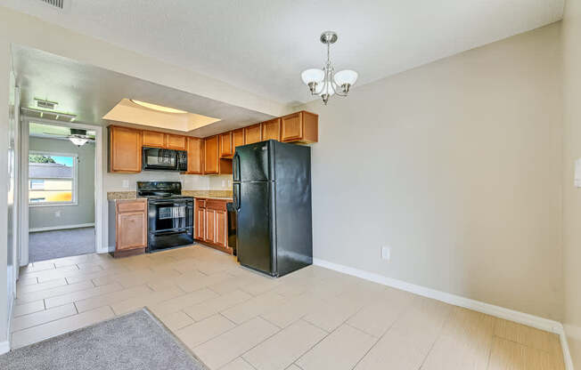 A kitchen with black appliances and wooden cabinets.