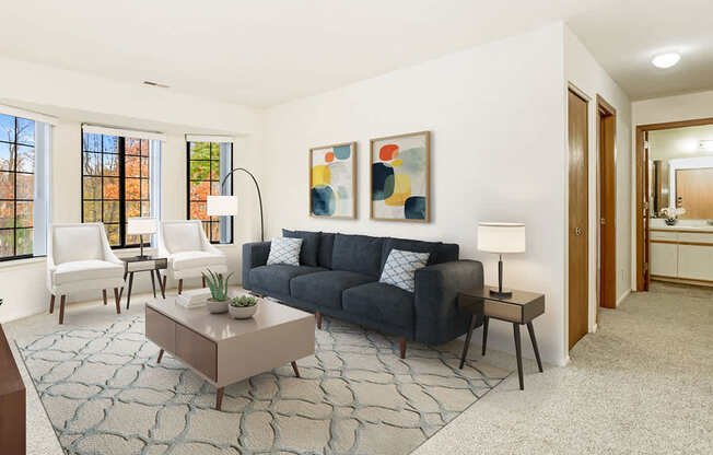 A living room with bay windows and grey couch at Tanglewood Apartments, Oak Creek