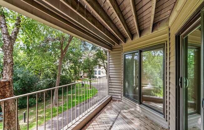 the screened in porch has a view of the yard and trees