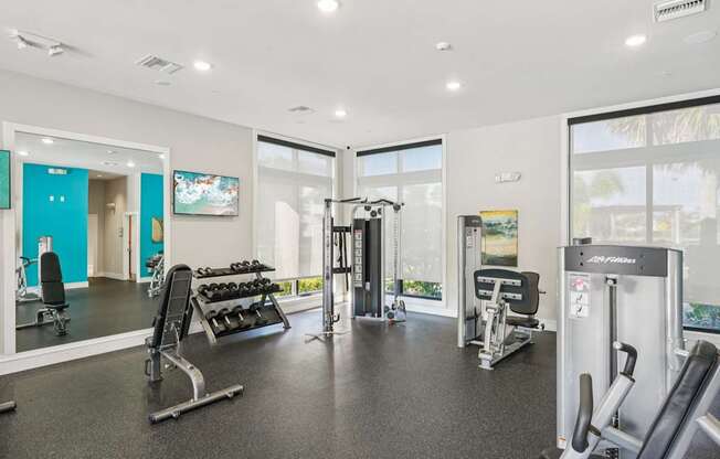 A gym with a variety of equipment including weights and cardio machines.