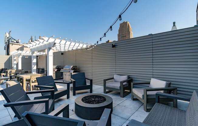 a roof top patio with chairs and tables and a fire pit