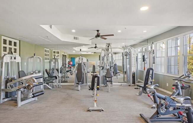 A spacious gym with a variety of equipment including treadmills, stationary bikes, and weight machines.