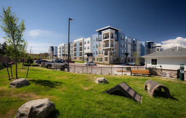 a grassy area with rocks in front of an apartment building